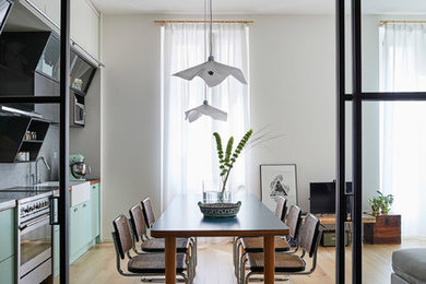 Foto di una sala da pranzo aperta verso il soggiorno minimal di medie dimensioni con pareti bianche, parquet chiaro e pavimento beige