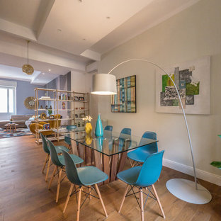 Esempio di una sala da pranzo aperta verso il soggiorno design di medie dimensioni con pareti grigie, pavimento in legno massello medio e nessun camino