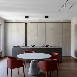 Idee per una sala da pranzo aperta verso la cucina contemporanea con pareti grigie, pavimento in legno massello medio e pavimento marrone