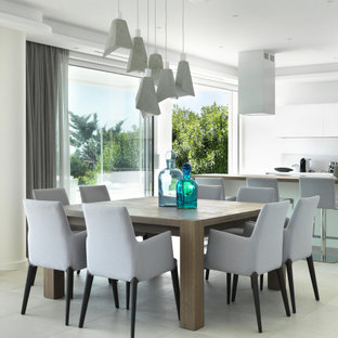 Immagine di una sala da pranzo aperta verso la cucina minimal di medie dimensioni con pareti bianche, pavimento in gres porcellanato e pavimento bianco