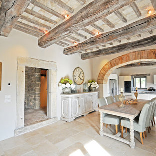 Esempio di un'ampia sala da pranzo aperta verso il soggiorno country con pavimento in pietra calcarea, pavimento beige e pareti bianche