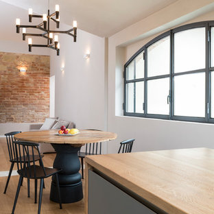 Immagine di una sala da pranzo aperta verso il soggiorno country di medie dimensioni con parquet chiaro, pareti bianche e pavimento beige