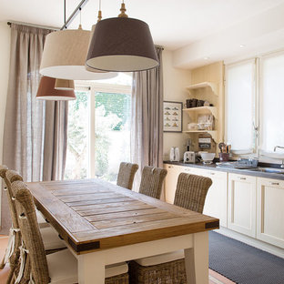 Esempio di una sala da pranzo aperta verso la cucina country di medie dimensioni con pareti bianche, pavimento in terracotta e pavimento arancione