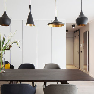 Cette photo montre une salle à manger tendance de taille moyenne avec un mur blanc, un sol en bois clair et aucune cheminée.