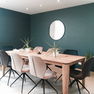 Aménagement d'une salle à manger contemporaine avec un mur vert, aucune cheminée et un sol beige.