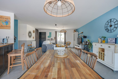 Exemple d'une grande salle à manger ouverte sur le salon bord de mer avec un mur bleu, un sol en carrelage de céramique et un sol gris.