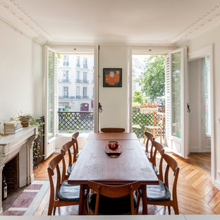 Ispirazione per una sala da pranzo mediterranea di medie dimensioni con pareti bianche, pavimento in legno massello medio e camino classico