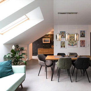Aménagement d'une salle à manger ouverte sur le salon contemporaine avec un mur blanc et un sol gris.