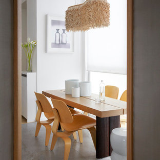 Inspiration pour une salle à manger nordique fermée et de taille moyenne avec un mur blanc, béton au sol et aucune cheminée.