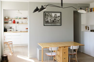 Imagen de comedor bohemio de tamaño medio abierto sin chimenea con paredes grises y suelo de madera clara