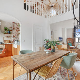 Idée de décoration pour une salle à manger ouverte sur le salon nordique de taille moyenne avec un sol en bois clair, un mur blanc et aucune cheminée.