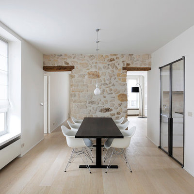 Example of a large trendy light wood floor enclosed dining room design in Paris with white walls and no fireplace
