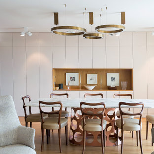 Aménagement d'une grand salle à manger ouverte sur le salon contemporaine avec un mur blanc, un sol en bois clair et un sol beige.
