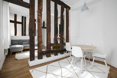 Idées déco pour une salle à manger ouverte sur le salon contemporaine de taille moyenne avec un mur blanc, parquet clair et un sol marron.