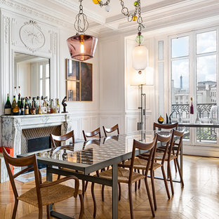 Idée de décoration pour une grand salle à manger ouverte sur le salon tradition avec un mur blanc, un sol en bois clair, un manteau de cheminée en pierre et une cheminée standard.