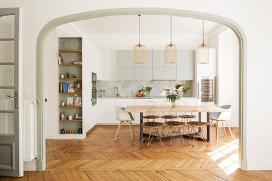 Imagen de comedor escandinavo de tamaño medio abierto sin chimenea con paredes blancas, suelo marrón y suelo de madera en tonos medios