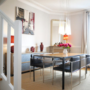 Réalisation d'une grand salle à manger ouverte sur le salon bohème avec un mur blanc, un sol en bois clair, une cheminée d'angle et un manteau de cheminée en pierre.