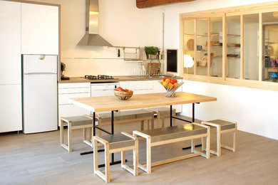 Cette image montre une salle à manger ouverte sur la cuisine nordique de taille moyenne avec un mur blanc, un sol en vinyl et aucune cheminée.