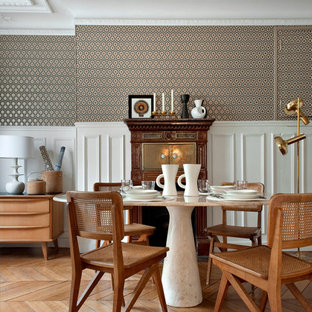 This is an example of a mid-sized transitional dining room in Paris with multi-coloured walls and medium hardwood floors.