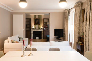 Geschlossenes, Großes Modernes Esszimmer mit beiger Wandfarbe, hellem Holzboden, Kamin, Kaminumrandung aus Stein und beigem Boden in Paris