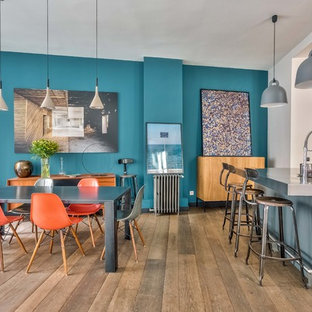 Exemple d'une salle à manger ouverte sur la cuisine chic avec un mur bleu, un sol en bois brun et un sol marron.
