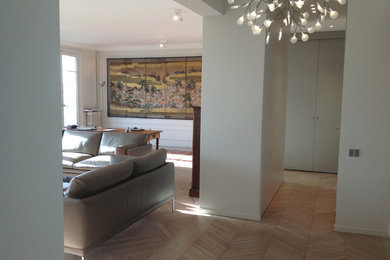 パリにある高級な中くらいなコンテンポラリースタイルのおしゃれなLDK (ベージュの壁、淡色無垢フローリング、標準型暖炉、石材の暖炉まわり、ベージュの床) の写真