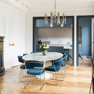 Aménagement d'une salle à manger ouverte sur la cuisine contemporaine avec un mur blanc, un sol en bois clair, un poêle à bois et un sol beige.