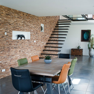 Exemple d'une salle à manger tendance avec un mur marron et un sol noir.