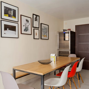 Inspiration pour une salle à manger design fermée et de taille moyenne avec aucune cheminée, un mur beige et un sol en carrelage de céramique.