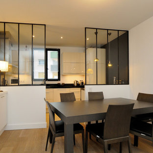 Idée de décoration pour une salle à manger ouverte sur la cuisine design de taille moyenne avec un mur blanc, un sol en bois brun et aucune cheminée.