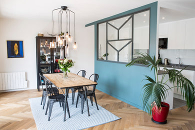 Idées déco pour une grande salle à manger ouverte sur le salon scandinave avec un mur bleu, parquet clair, aucune cheminée et un sol marron.