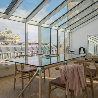 Cette photo montre une salle à manger éclectique avec un mur blanc, un sol en bois clair et un sol beige.