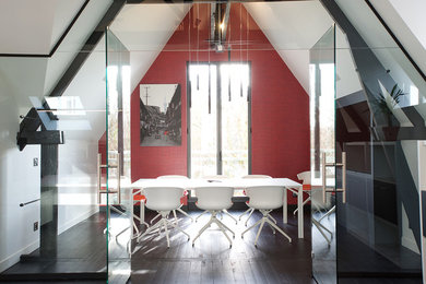 Aménagement d'une salle à manger ouverte sur le salon contemporaine de taille moyenne avec un mur rouge, parquet peint, aucune cheminée et un sol noir.