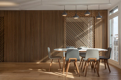 Cette image montre une salle à manger ouverte sur le salon design de taille moyenne avec un mur marron, parquet clair, aucune cheminée et un sol marron.