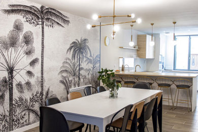 Cette photo montre une grande salle à manger ouverte sur le salon tendance avec un mur blanc, un sol en bois brun et du papier peint.