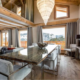 Inspiration pour une salle à manger ouverte sur le salon chalet de taille moyenne avec un mur beige, un sol en bois clair et aucune cheminée.