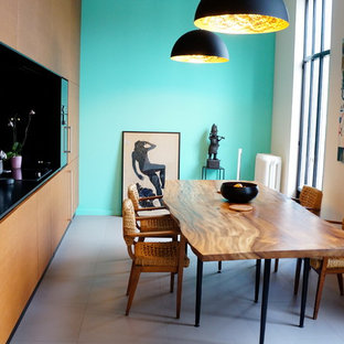 Réalisation d'une salle à manger ouverte sur la cuisine design de taille moyenne avec un mur bleu, béton au sol et aucune cheminée.