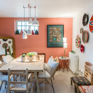 Inspiration pour une salle à manger bohème avec un mur rouge, béton au sol et un sol gris.
