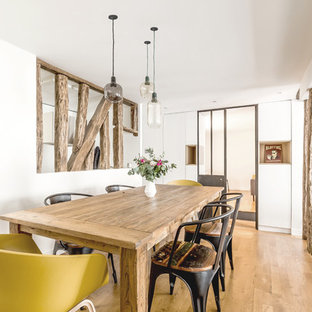 Exemple d'une salle à manger ouverte sur le salon scandinave de taille moyenne avec un mur blanc, un sol en bois clair et aucune cheminée.