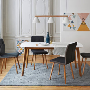 Idée de décoration pour une salle à manger nordique avec un mur blanc et un sol en bois brun.