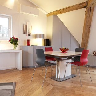Cette photo montre une grand salle à manger ouverte sur le salon tendance avec un mur blanc, un sol en bois brun et aucune cheminée.