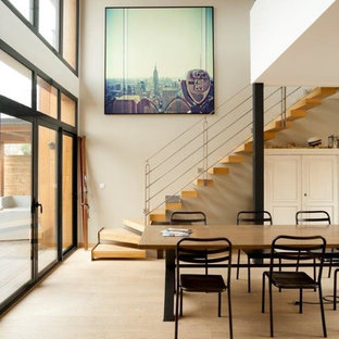 Idée de décoration pour une grand salle à manger ouverte sur le salon design avec un mur beige, un sol en bois clair et aucune cheminée.
