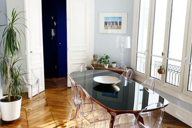 Cette image montre une salle à manger ouverte sur le salon de taille moyenne avec un mur bleu et parquet clair.