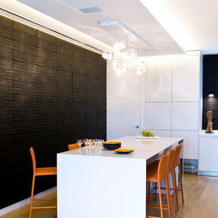Réalisation d'une grand salle à manger ouverte sur le salon design avec un sol en bois clair et un mur noir.