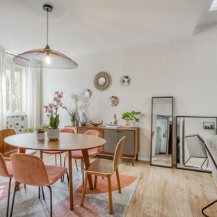 Exemple d'une salle à manger ouverte sur le salon tendance de taille moyenne avec un mur blanc, aucune cheminée, un sol en bois clair, un sol beige et du papier peint.