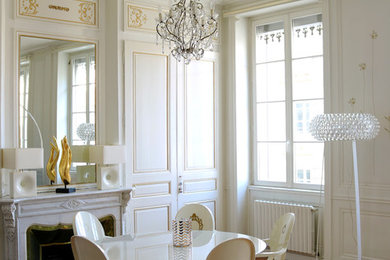 Exemple d'une salle à manger ouverte sur le salon chic de taille moyenne avec un mur blanc, un sol en bois brun, une cheminée standard, un manteau de cheminée en pierre et éclairage.