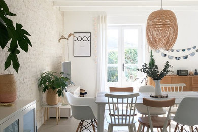 Idée de décoration pour une salle à manger nordique avec un mur blanc et un sol gris.