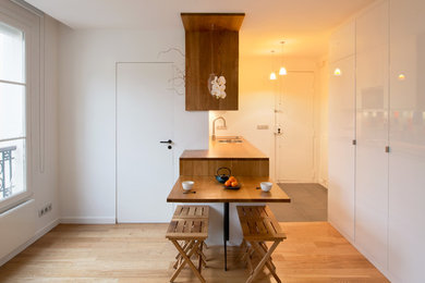 Idee per una piccola sala da pranzo aperta verso la cucina minimal con pareti bianche, parquet chiaro e nessun camino