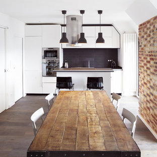 Ejemplo de comedor de cocina contemporáneo, grande, con paredes blancas y suelo de madera en tonos medios