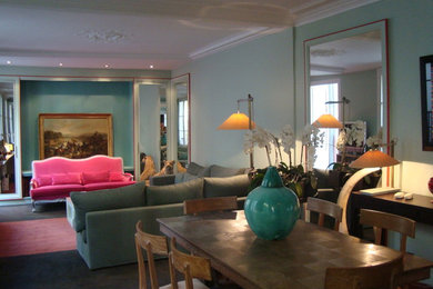 Aménagement d'une grande salle à manger ouverte sur le salon classique avec un mur vert, moquette et un sol multicolore.